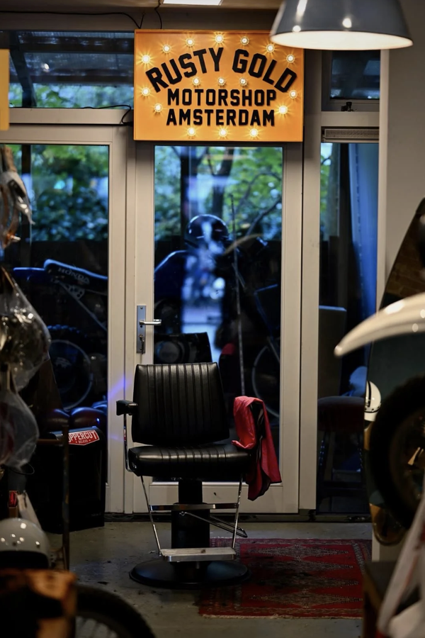 The Wolf Barbers chair among the riding gear and helmets in Rusty Gold